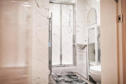格拉斯哥S.H Apartments的白色的浴室设有卫生间和窗户。