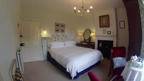 科克茅斯Wood House的卧室配有一张白色大床和吊灯。
