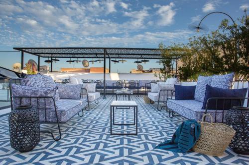 马拉喀什Le Pavillon de la Kasbah & SPA Marrakech的庭院配有蓝色和白色的椅子和桌子