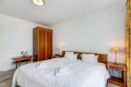 赛巴特班森Seehof Wohnung 1.33的卧室配有一张白色大床和两条毛巾