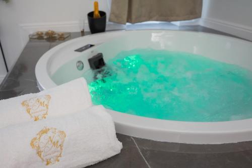 庞贝NM Luxury Suites的浴室设有装满蓝色水的浴缸。