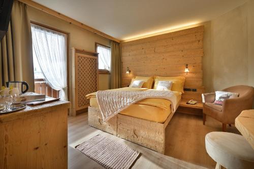 利维尼奥Hotel Costanza Mountain Holiday的一间卧室设有一张床和木墙