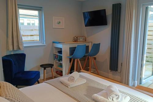 卡比斯贝Stylish coastal retreat in St Ives的一间卧室配有一张床、两把椅子和一张书桌