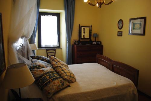 博尔塞纳The garden of history的卧室配有带枕头的床铺和窗户。