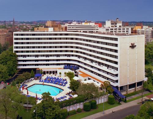 华盛顿华盛顿广场酒店的一座白色的大建筑,前面设有一个游泳池
