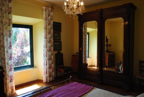 博尔塞纳The garden of history的一间卧室配有大镜子和吊灯