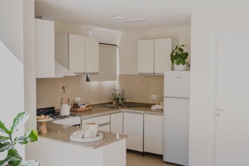 埃斯克尔El Coiron Aparts的厨房配有白色橱柜和白色冰箱。