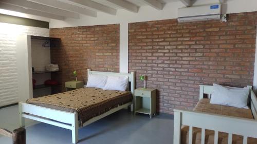 ZondaSolar Del Valle的一间卧室设有一张床和砖墙