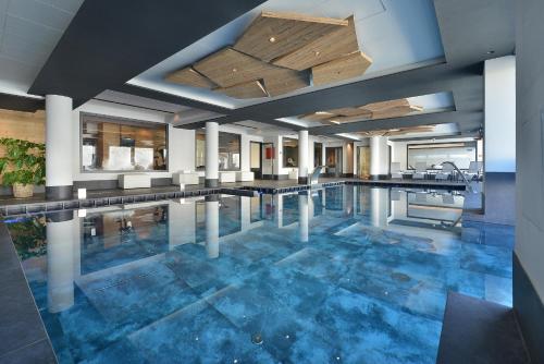 利维尼奥普卡尼维酒店的大楼内一个蓝色瓷砖的大型游泳池