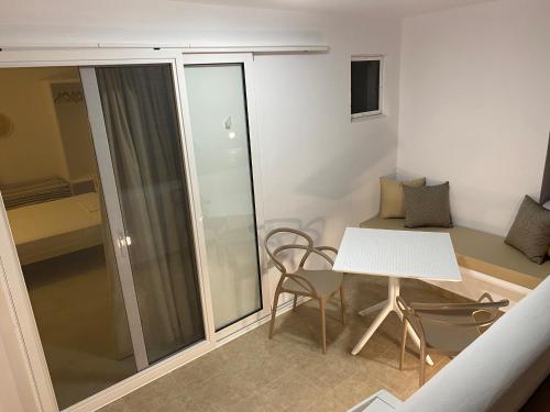 阿吉奥斯普罗科皮奥斯尼克莱塔一室公寓酒店的一间小公寓,配有白色的桌子和椅子