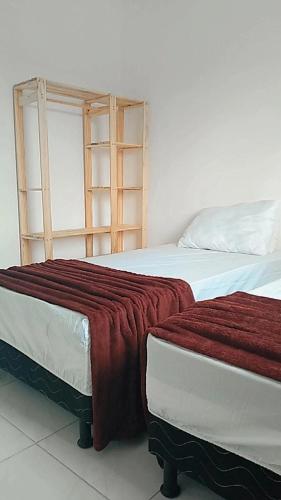 Coroa VermelhaPraia dos Corais - Bahia的两张睡床彼此相邻,位于一个房间里