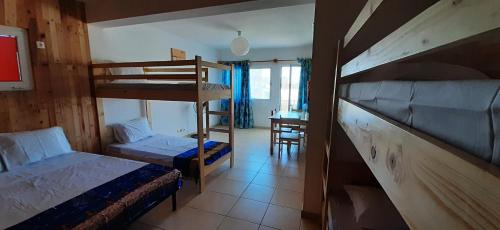 圣玛丽亚AH Xamedu Sal Hostel的一间卧室配有两张双层床和一张书桌