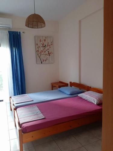 尼亚普拉加CHALKIDIKI NEA PLAGIA的一间卧室配有一张大床和紫色毯子
