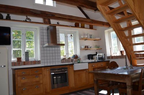 赫加奈斯Hönshuset Kullabygden的一个带木制橱柜和桌子的大厨房