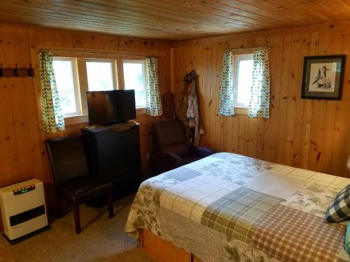 费尔班克斯Northwoods Cottage Bed and Breakfast的一间卧室配有一张床、一把椅子和窗户。