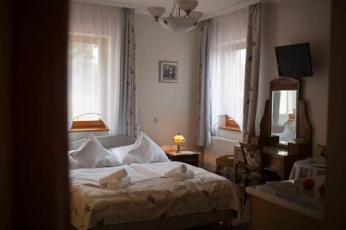 毛科LuDo Apartman Hotel & Spa的一间卧室配有带白色床单和枕头的床。