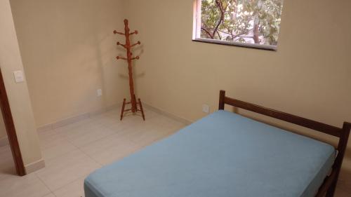 瓜拉派瑞Praia de Setiba - Kitnet的一间小卧室,配有一张床和一个小窗户