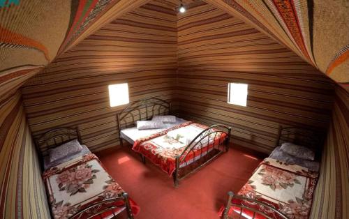 瓦迪拉姆萨勒姆营地酒店的一间小房间,在木制房间内配有两张床