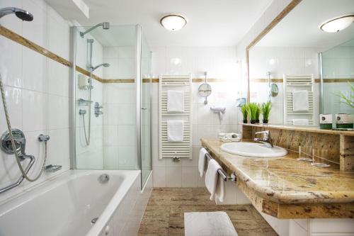 蒂罗尔-泽费尔德HENRI Country House Seefeld的带浴缸、水槽和淋浴的浴室