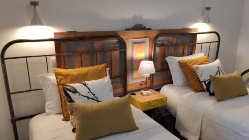 奥比多斯LARANJEIRA das LOIRAS的客房设有两张床和一张带台灯的桌子。