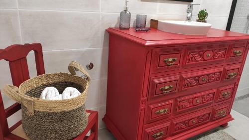 奥比多斯LARANJEIRA das LOIRAS的红色浴室梳妆台,配有水槽和一篮毛巾
