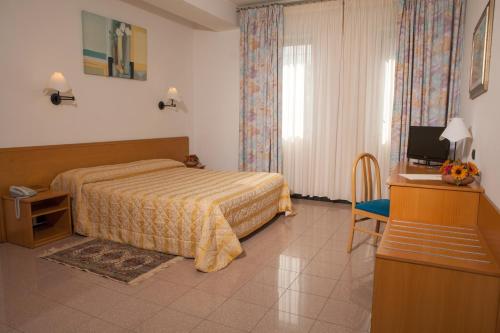 阿尔贝罗贝洛阿斯托利亚酒店的酒店客房,配有床和电视