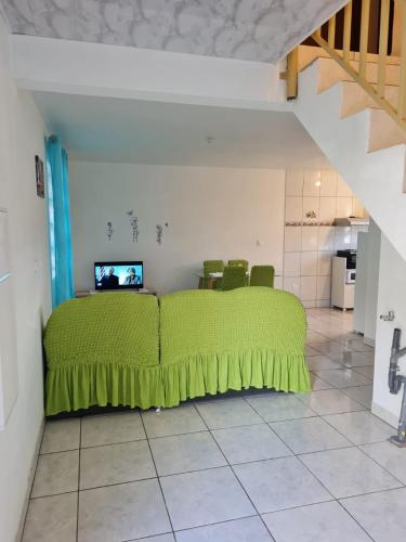 马罗尼河畔圣洛朗CHEZ VERVEINE的一间位于客房内的带绿床的卧室