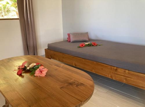 波拉波拉FARE ARIITEA的一间设有两张床的房间和一张鲜花桌子