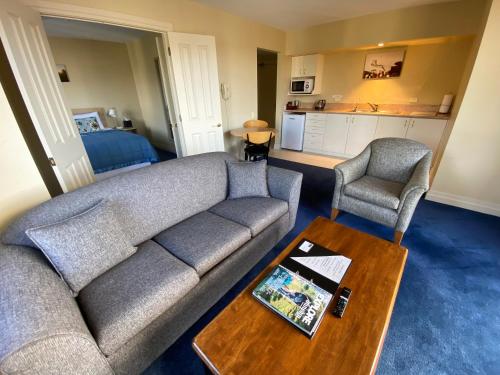 但尼丁纽约汽车旅馆的客厅配有沙发、两把椅子和一张桌子