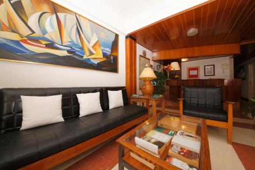 洛斯·亚诺斯·德·阿里丹爱登酒店的客厅配有黑色沙发和玻璃桌