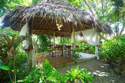 长滩岛Mandala Spa & Resort Villas的一个带桌子和椅子的稻草伞下庭院