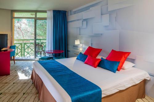圣拉斐尔加里格爱斯特尔酒店的一间卧室配有一张带红色和蓝色枕头的大床