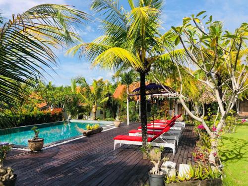 乌鲁瓦图乌鲁瓦图微风村假日公园的一个带游泳池的度假胜地和一个棕榈树度假胜地