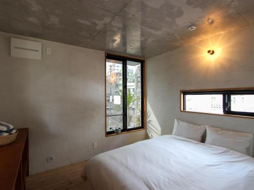那霸ON THE SAME HOTEL-All suite-的卧室设有一张白色大床和一扇窗户。