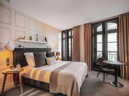 雷恩Balthazar Hôtel & Spa Rennes - MGallery Hotel Collection的一间卧室配有一张床、一张桌子和一张书桌