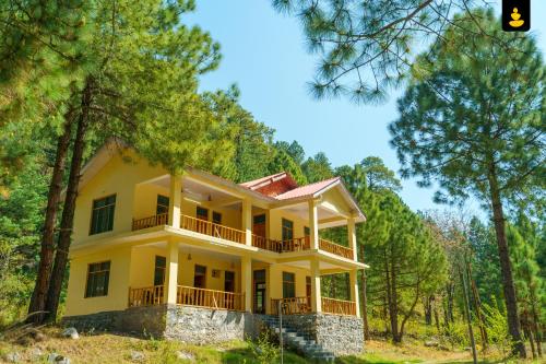 本贾尔LivingStone Backwater Resort Tirthan Valley的树林中的黄色房子