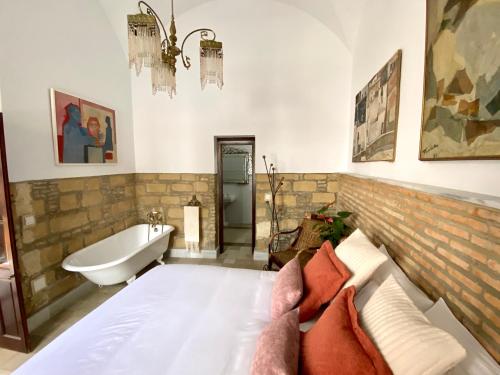 赫雷斯-德拉弗龙特拉Casa Palacio Ánima的一间带浴缸、床和浴缸的卧室