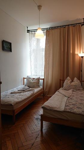克拉科夫Words & Swords的两张床位于带窗户的房间内