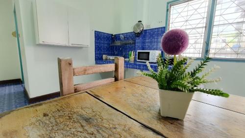 卡伦海滩Karon house 15A的厨房配有木桌和植物