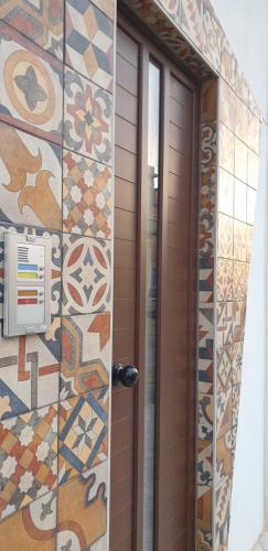 兰佩杜萨RgB_Apartments的墙上有彩色瓷砖的棕色门