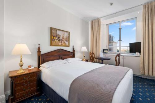 悉尼Castlereagh Boutique Hotel, Ascend Hotel Collection的酒店客房设有一张床和一个大窗户