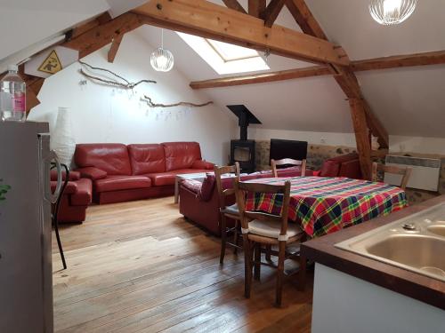 BescatUn petit coin d'OSSAU的客厅配有红色的沙发和桌子