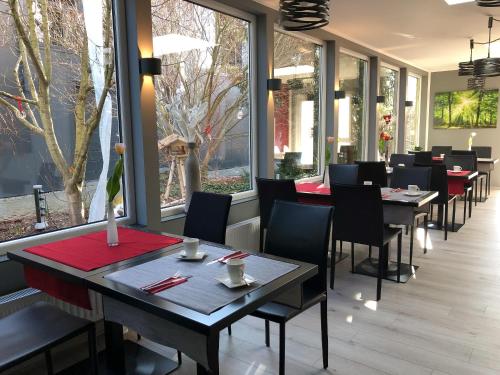 梅明根梅明根北奥伽酒店的餐厅设有桌椅和窗户。
