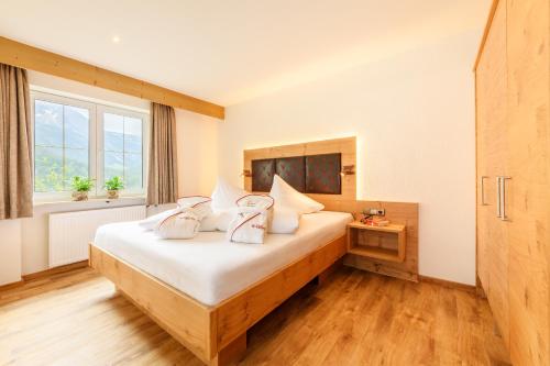 米特尔贝格德尔克莱恩瓦尔赛塔勒罗森霍夫旅馆的一间卧室配有一张带白色床单的床和一扇窗户。