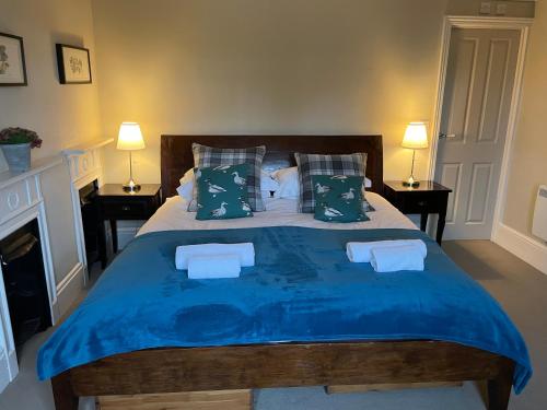 FuntingtonThe Richmond Arms Rooms的一间卧室配有一张大床,提供蓝色的床单和枕头