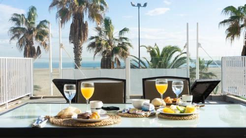 瓦伦西亚竞技场酒店的海滩阳台的桌子上摆放着食物和饮料