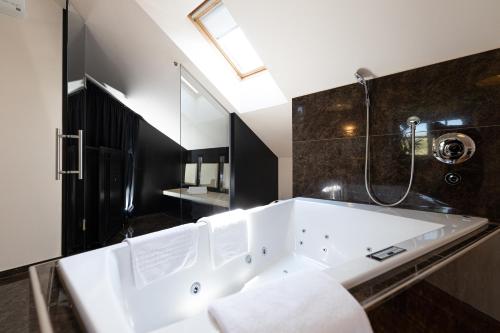 延纳斯多夫Hotel TraumVogel的浴室内设有大型白色浴缸。