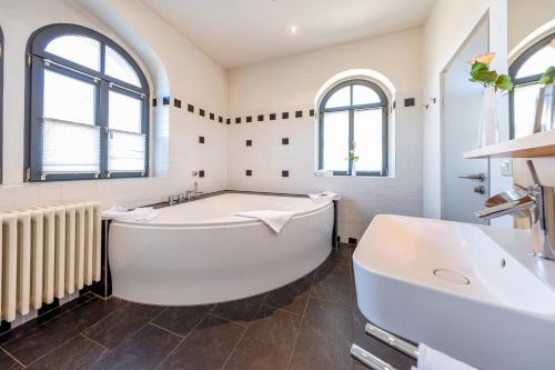 拉德博伊尔Spitzhaus的白色的浴室设有浴缸和水槽。