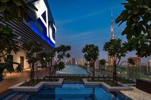 迪拜Paramount Hotel Midtown的享有带游泳池和城市的建筑景致
