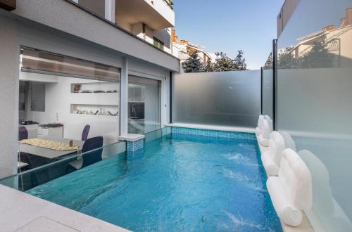 斯普利特Luxury apartment Martinis with pool的一座房子里带滑梯的无边游泳池